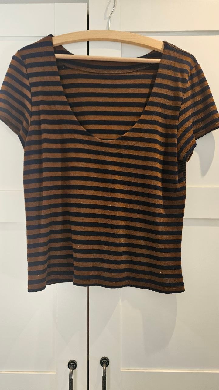 Selbst genähtes Shirt mit braunen und dunklen Streifen auf einem Holzbügel.